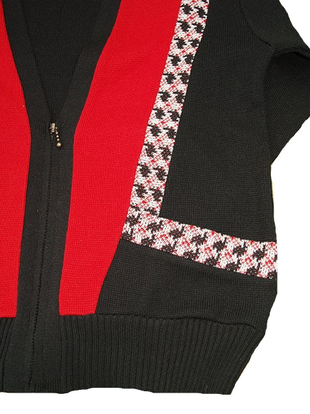 Black cardigan with red zipper and floral pattern on a beige background