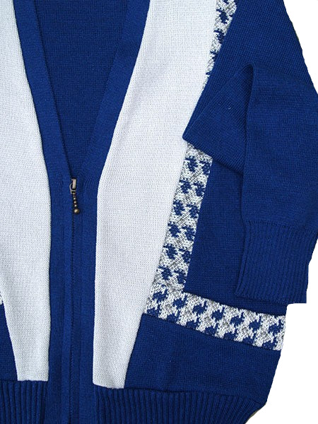 Blue and white cardigan with patterned trim on a beige background