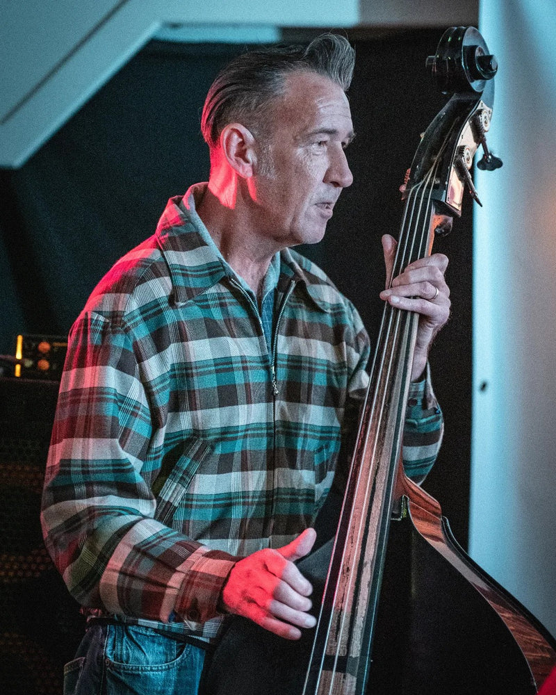 Man playing a double bass in a studio setting